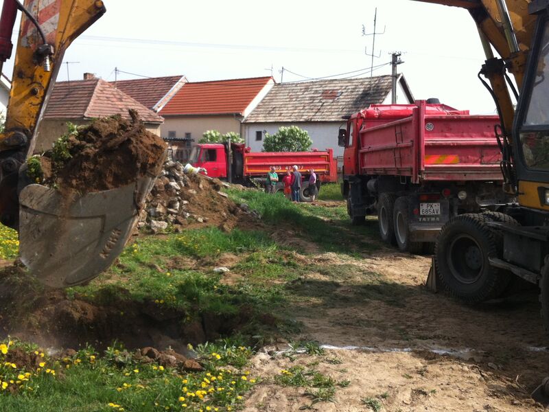 Bager a nákladné auto pri začiatku stavby